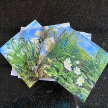 Image of the 4 greeting cards designs and  with woodland inspired designs on a dark surface