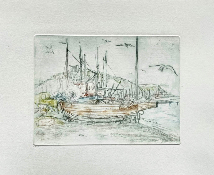 Drypoint Etching of boats pulled up on the shingle at Hastings with seagulls flying around coloured inks on cream background