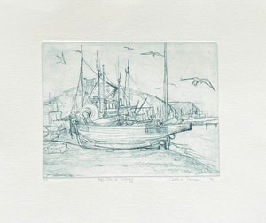 Drypoint Etching of boats pulled up on the shingle at Hastings with seagulls flying around  grey ink on cream background