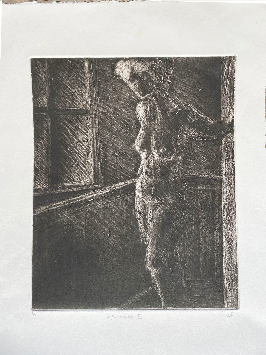 Etching of a female nude  by a window prints in very dark brown on creamy white paper with hand torn edges
