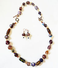 randomly selected handmade beads used to make a  necklace, bracelet  and similar earrings set on a white background