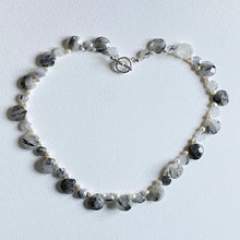 Necklace with grey and white cut stones mixed with pearls  on a white background