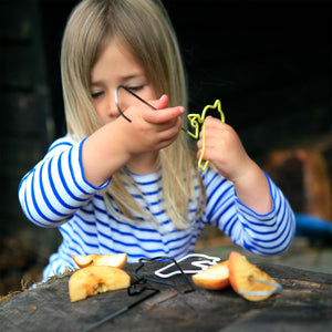 Girl putting apple bits onto a wire Bird Feeder